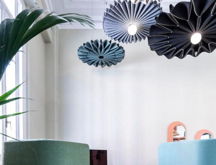 Panneau acoustique BuzziPleat Ø100 ou Ø150 installé au-dessus d’une table de réunion pour améliorer le confort sonore.