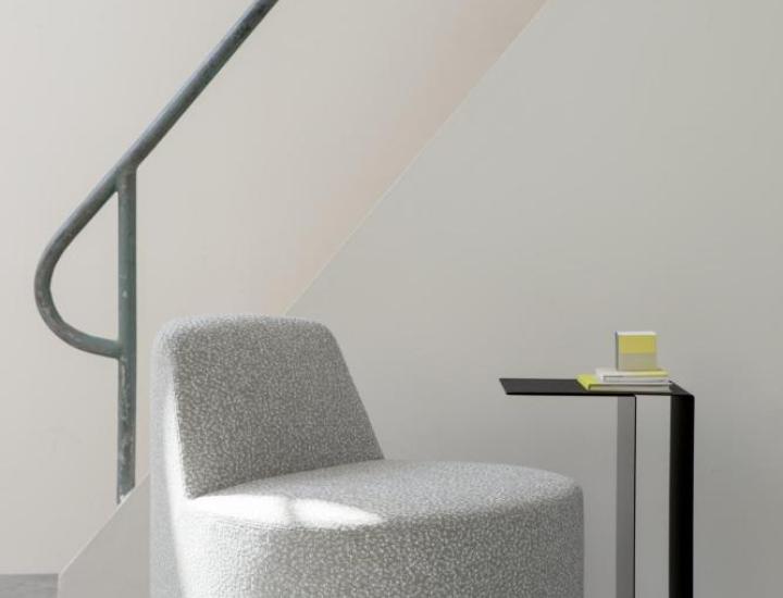 U2 XL Cascando près d’un canapé – table d’appoint à glisser sur l’assise avec porte-magazines.