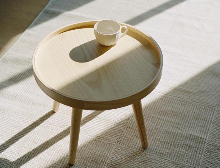 Table basse ALMA Softline avec coussin dans un espace lounge contemporain.