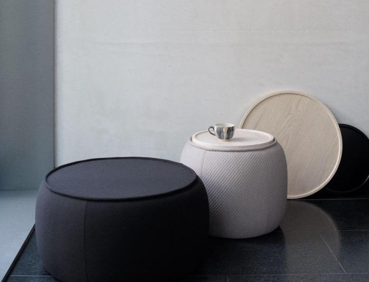 Pouf CONGA Softline avec plateau bois dans un espace lounge contemporain.