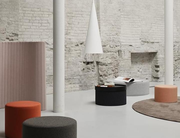Pouf DRUM Softline avec plateau dans un espace lounge contemporain.