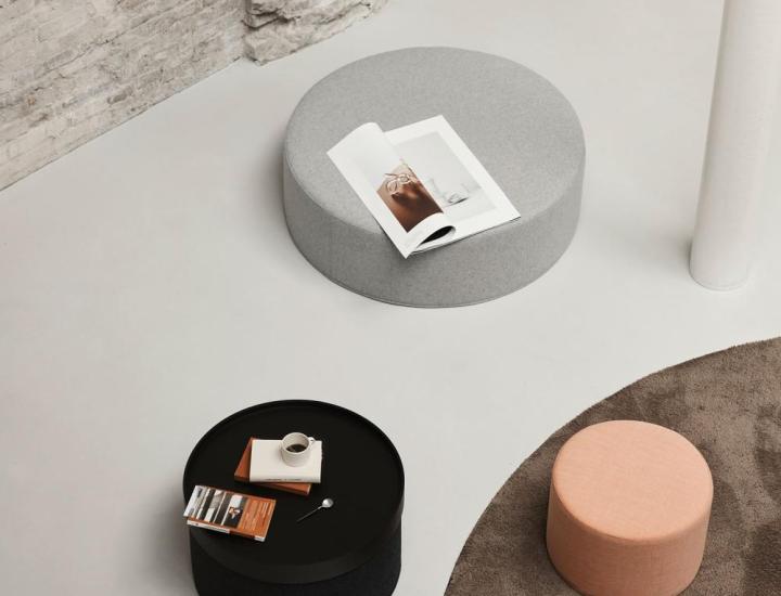 Table basse et pouf DRUM Softline dans un aménagement professionnel élégant.