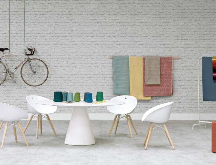Gros plan sur le piétement conique en polyéthylène blanc de la table Ikon Pedrali, usage extérieur, terrasse dallée lumineuse