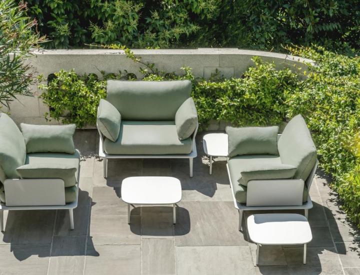 Fauteuil lounge Reva Pedrali disposé en terrasse de villa avec vue dégagée, coussins blancs, structure aluminium sablé, ambiance resort luxe