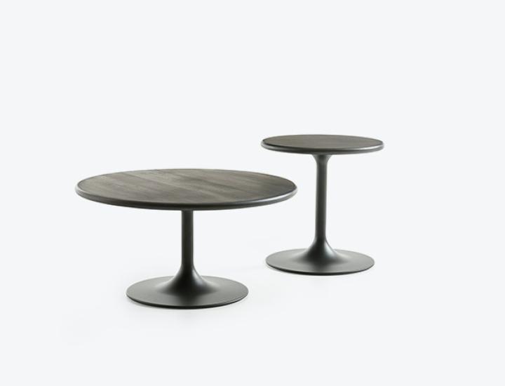 Duo de tables basses rondes Clarion Low Artifort. Le modèle table basse au premier plan et le modèle table d'appoint à l'arrière-plan, toutes deux avec une base tulipe noire et un plateau texturé en bois sombre, isolées sur fond blanc.