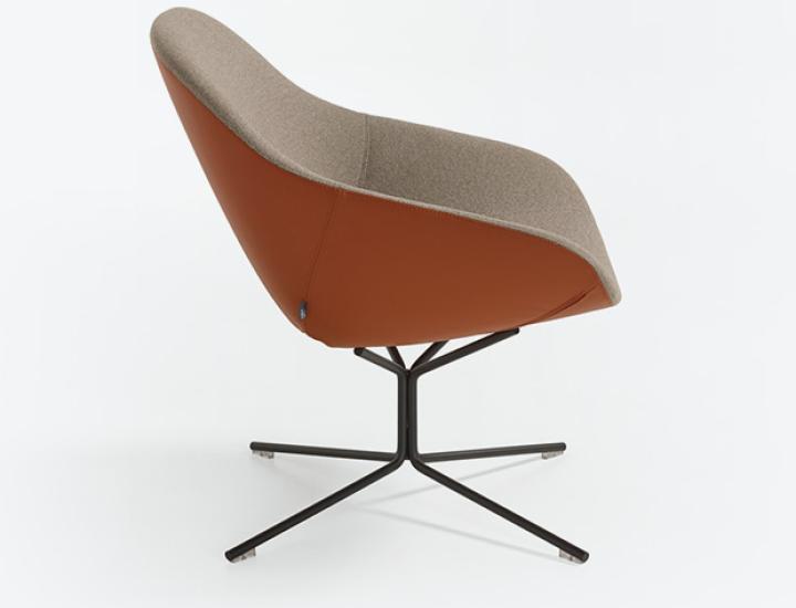 Un fauteuil moderne vu de profil et de trois quarts arrière, mettant en valeur un revêtement bicolore. L'extérieur de la coque est de couleur marron cognac, tandis que l'intérieur de l'assise et du dossier est recouvert d'un tissu beige chiné. Le fauteuil repose sur un piétement métallique noir à quatre branches en croix. L'objet est présenté sur un fond de studio blanc.